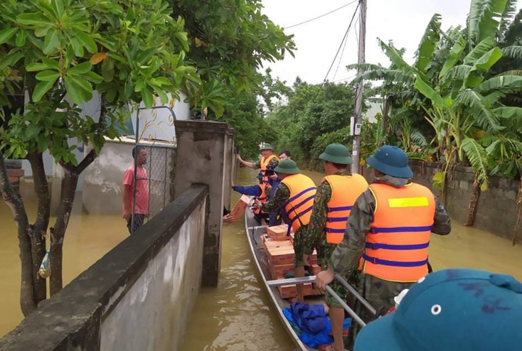 Tổ công tác của Ban Chỉ huy Quân sự huyện Quảng Ninh cấp phát hàng cứu trợ cho các hộ dân vùng đang ngập lụt nặng.