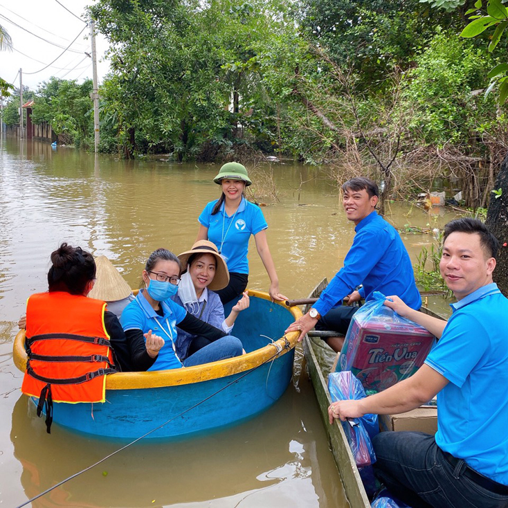 Các tình nguyện viên dùng các phương tiện thuyền, thúng để vận chuyển hàng trao tận nơi hỗ trợ người cho dân đang bị ngập lụt nặng ở xã Tân Ninh (Quảng Ninh)