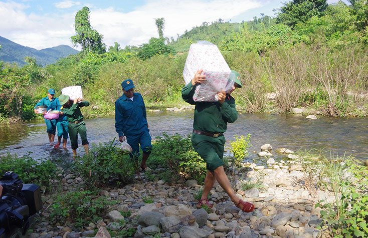 Cán bộ, chiến sỹ băng rừng, vượt suối để mang quà cho các em học sinh. 