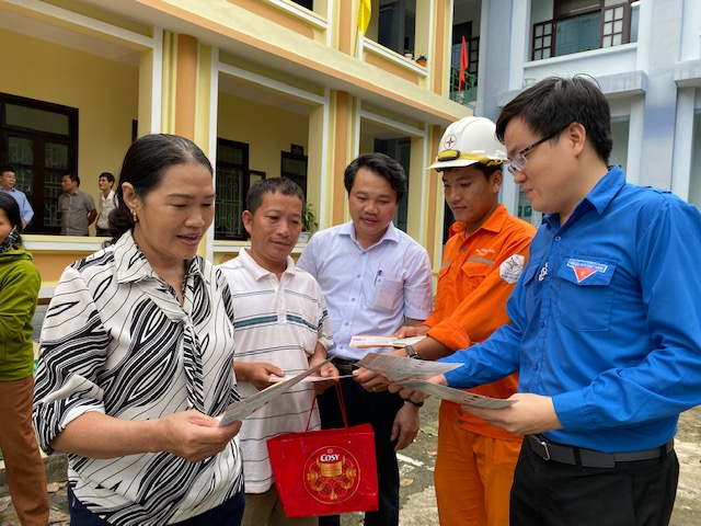 Cán bộ PC Quảng Bình phát tờ rơi tuyên truyền sử dụng điện an toàn cho người dân.