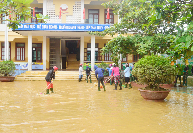 Cán bộ, giáo viên Trường tiểu học số 1 An Thủy, huyện Lệ Thủy thau rửa bùn đất trên sân trường còn ngập nước.