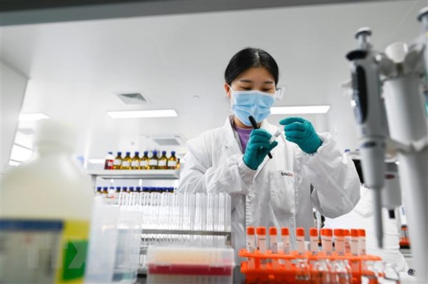  Kỹ thuật viên làm việc tại phòng thí nghiệm nghiên cứu vắcxin COVID-19 tại Bắc Kinh, Trung Quốc, ngày 24-9-2020. (Ảnh: AFP/TTXVN)