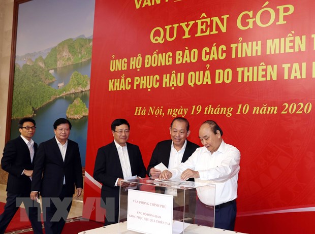 Thủ tướng Nguyễn Xuân Phúc và các Phó Thủ tướng ủng hộ đồng bào niền Trung khắc phục hậu quả do do thiên tai lũ lụt. (Ảnh: Thống Nhất/TTXVN)