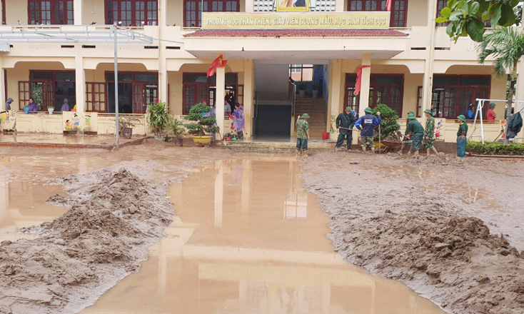 Các lực lượng đang giúp đỡ Trường tiểu học số 1 Sơn Trạch vệ sinh môi trường.