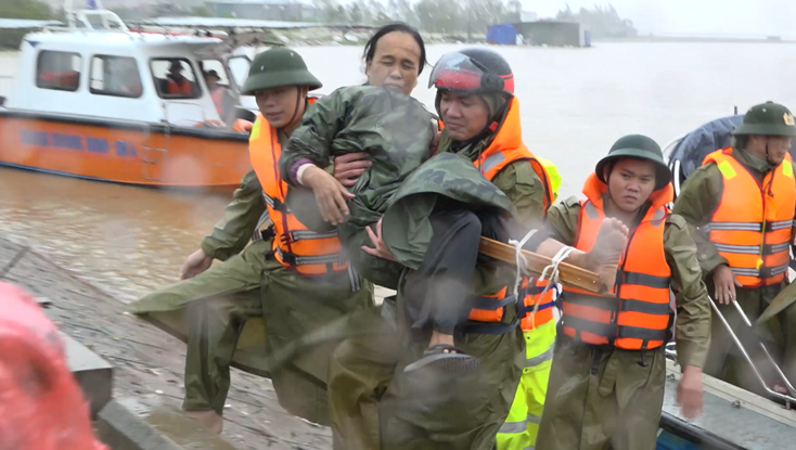 Cán bộ, chiến sỹ Công an thị xã Ba Đồn đưa bà Đinh Thị Xoài (59 tuổi, bị gãy chân) đi cấp cứu kịp thời trong tâm lũ.