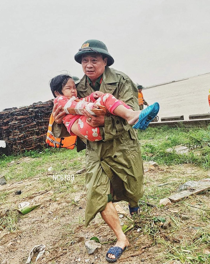 Thượng tá Lê Văn Hóa-Trưởng Công an thị xã Ba Đồn kịp thời đưa cháu Phạm Tường Vi (4 tuổi, bị gãy tay) trong tâm lũ để cấp cứu kịp thời.