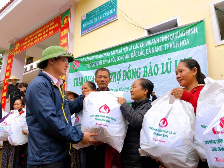 Lãnh đạo NHCSXH tỉnh thay mặt các ngân hàng trong hệ thống trao quà hỗ trợ đến tận tay bà con vùng lũ