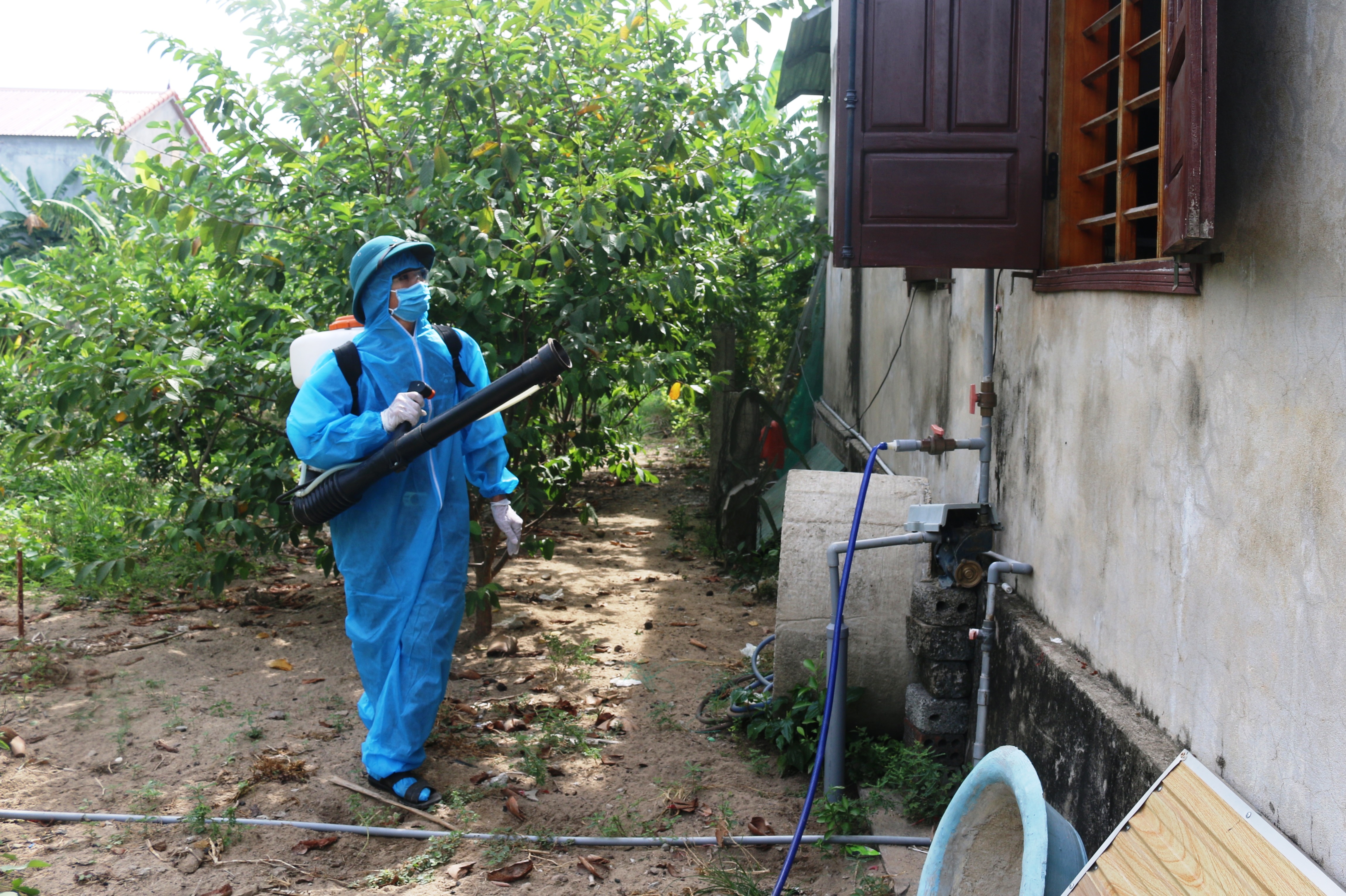   Cán bộ y tế đang phun hóa chất diệt muỗi tại nhà dân ở thôn Tròn, xã Vạn Trạch, huyện Bố Trạch.