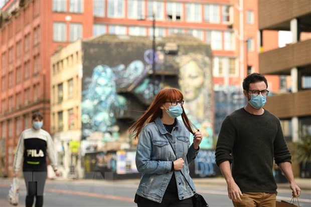 Người dân đeo khẩu trang phòng lây nhiễm COVID-19 tại Manchester, Anh. (Ảnh: AFP/TTXVN)