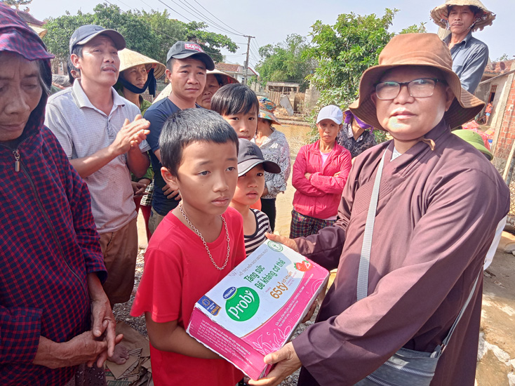 Sư cô Thích Tâm Hạnh băng qua vùng lũ để trao quà cho trẻ em và người dân ở thôn Vinh Quang xã Sơn Thủy (Lệ Thủy).