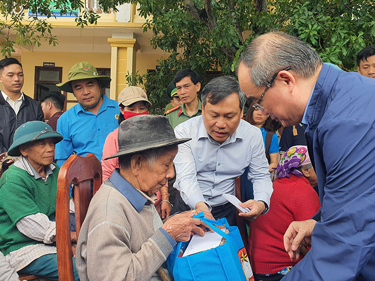 Đồng chí Ủy viên Bộ Chính trị Nguyễn Thiện Nhân và đồng chí Bí thư Tỉnh ủy Vũ Đại Thắng trao quà cho người dân xã Duy Ninh (huyện Quảng Ninh)   