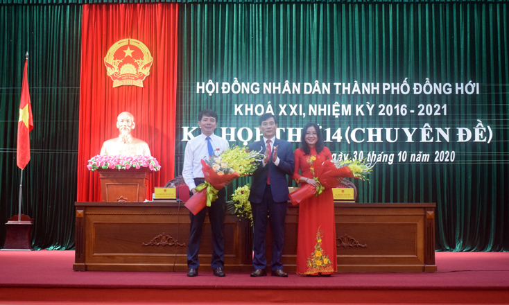 Đại diện HĐND TP. Đồng Hới tặng hoa chúc mừng tân Chủ tịch UBND và Phó Chủ tịch UBND TP. Đồng Hới nhiệm kỳ 2016-2021