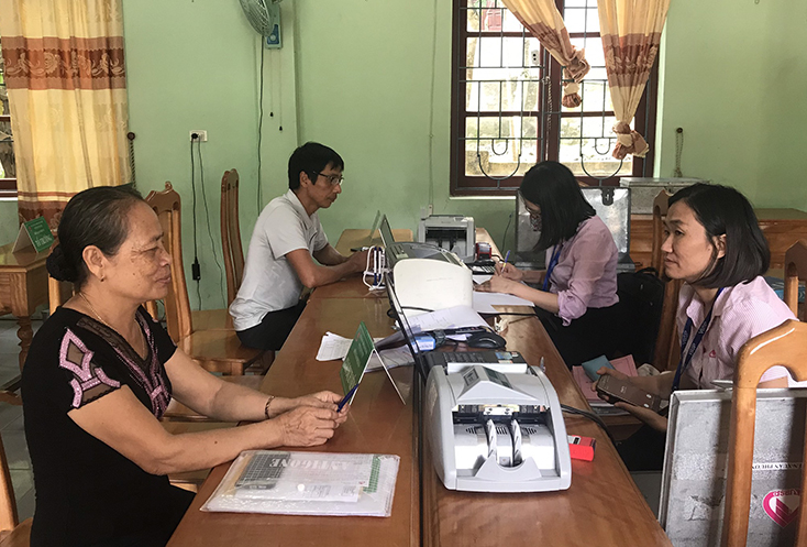 Chị Nguyễn Thị Nga tại phiên giao dịch định kỳ hàng tháng với cán bộ tín dụng PGD NHCSXH huyện Quảng Ninh. 