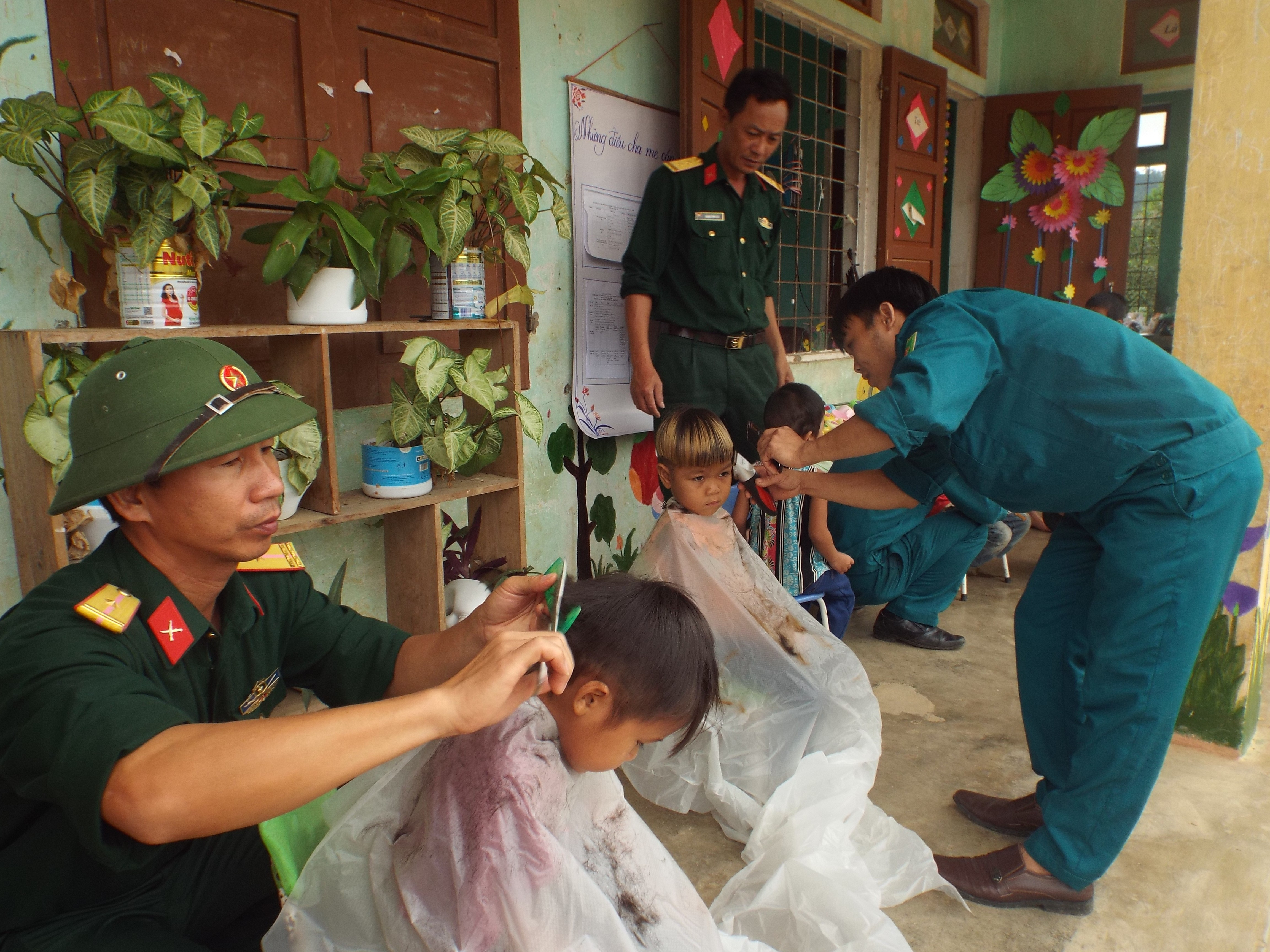  Cán bộ, chiến sỹ tổ chức cắt tóc cho các em học sinh dân tộc Chứt ở xã Lâm Hóa.