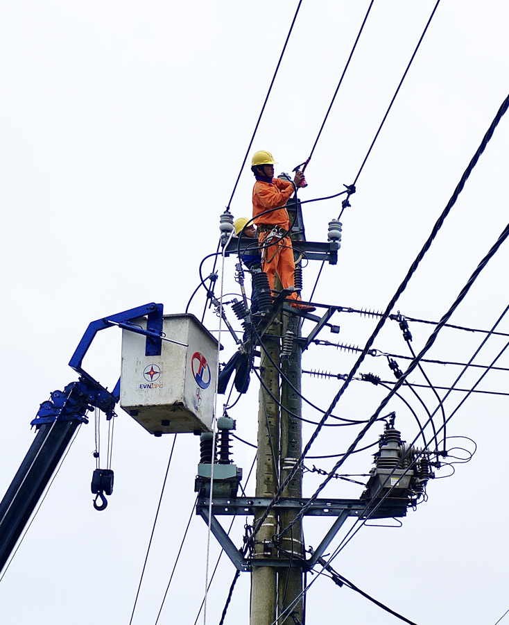 Công nhân PC Quảng Bình thi công nối đường đây điện bị đứt do bão số 13.
