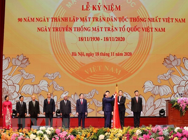 Thủ tướng Nguyễn Xuân Phúc, Chủ tịch Hội đồng Thi đua - Khen thưởng Trung ương gắn Huân chương Hồ Chí Minh lên lá cờ truyền thống của Mặt trận Tổ quốc Việt Nam. (Ảnh: Trí Dũng/TTXVN)