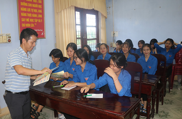 Cán bộ Sở Tư pháp phát tài liệu tuyên truyền PBGDPL cho học sinh Trường THPT Đồng Hới.