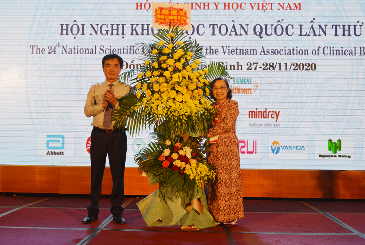 Đồng chí Phó Chủ tịch HĐND tỉnh Nguyễn Lương Bình tặng hoa chúc mừng hội nghị.