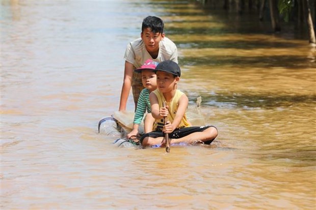 Trẻ em đẩy bè đi lấy hàng cứu trợ. (Ảnh: Thành Đạt/TTXVN)