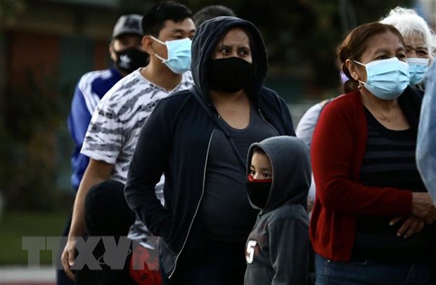  Người dân đeo khẩu trang phòng lây nhiễm COVID-19 khi xếp hàng chờ nhận hàng phân phát tại Los Angeles, California, Mỹ, ngày 19-11-2020. (Nguồn: THX/TTXVN)