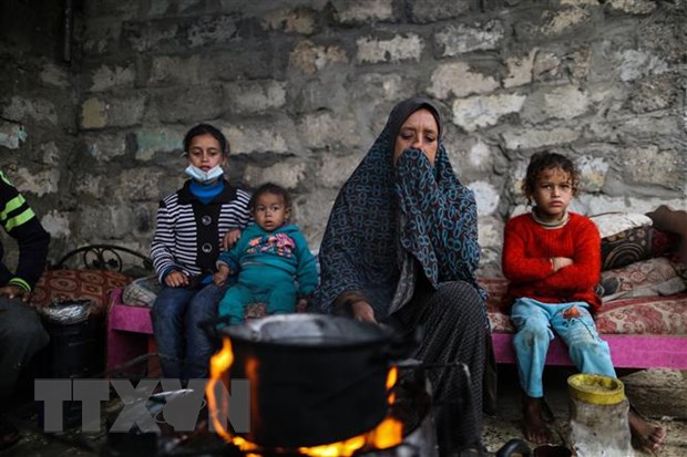 Người dân Palestine sưởi ấm tại trại tị nạn ở thành phố Khan Younis, Dải Gaza. (Ảnh: THX/TTXVN)