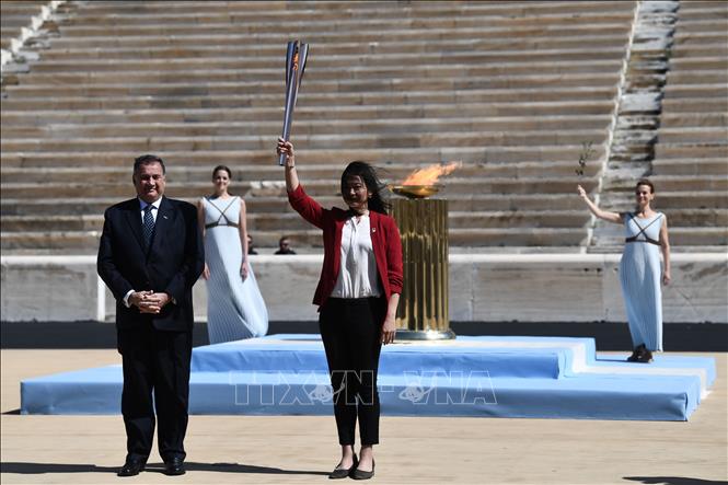  Bộ trưởng Thể thao Hy Lạp Spyros Capralos (trái) trao ngọn đuốc Olympic cho cựu vận động viên bơi lội Nhật Bản Imoto Naoko tại Athens, Hy Lạp, ngày 19-3-2020. Ảnh: AFP/TTXVN