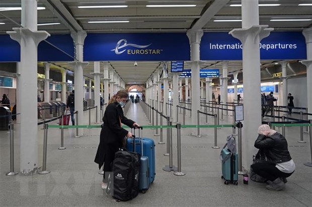  Hành khách đeo khẩu trang phòng lây nhiễm COVID-19 tại nhà ga quốc tế ở London, Anh, ngày 20-12-2020. (Ảnh: AFP/TTXVN)