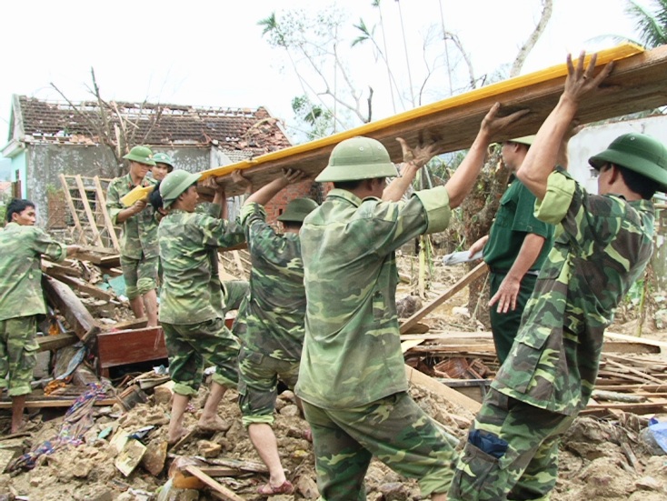 Bộ đội giúp dân dựng lại nhà cửa bị sập đổ do bão lũ. 