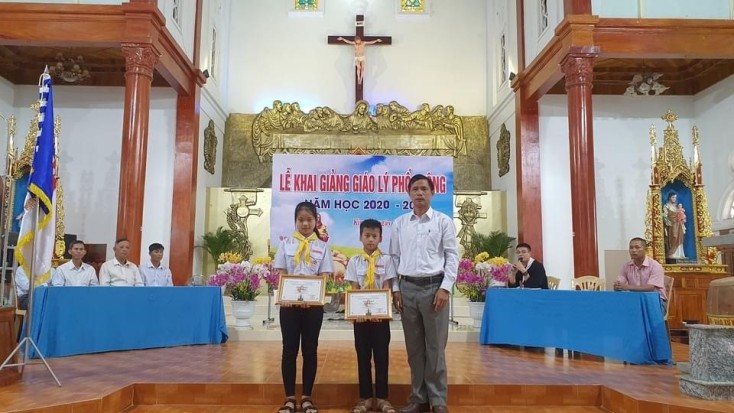 Ông Trương Quang Trọng, Trưởng ban Khuyến học giáo xứ trao thưởng cho các em học sinh xuất sắc năm học 2019-2020.