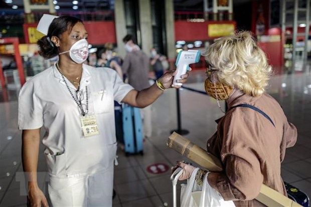 Nhân viên y tế Cuba kiểm tra thân nhiệt du khách nhằm ngăn ngừa dịch COVID-19 lây lan, tại một nhà khách ở Havana. (Ảnh: AFP/TTXVN)