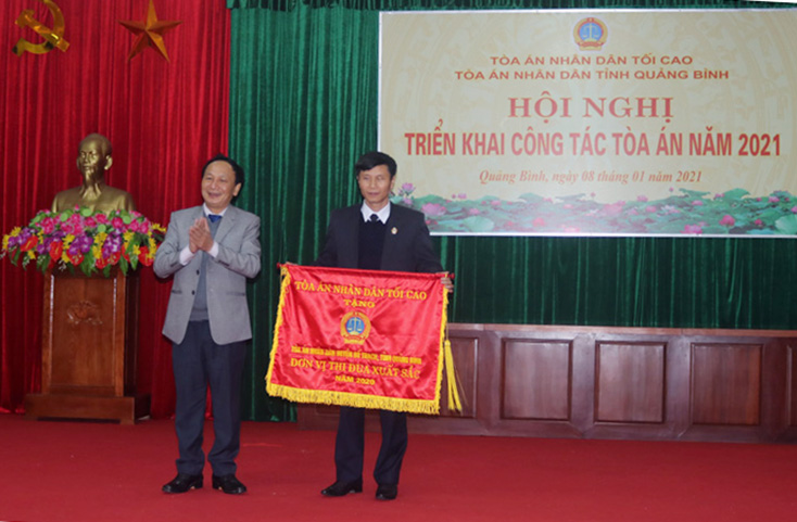Đồng chí Trần Hải Châu, Phó Bí thư Thường trực Tỉnh ủy, Chủ tịch HĐND tỉnh trao cờ thi đua  "Đơn vị xuất sắc năm 2020 " cho TAND huyện Bố Trạch.