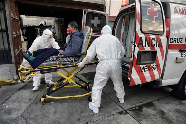 Nhân viên y tế chuyển bệnh nhân nhiễm COVID-19 lên xe cứu thương tại Toluca, Mexico. (Ảnh: AFP/TTXVN)