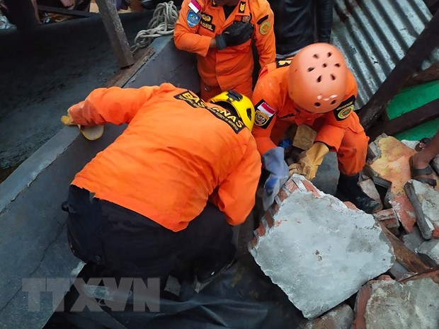 Lực lượng cứu hộ tìm kiếm nạn nhân dưới đống đổ nát. (Ảnh: AFP/TTXVN)