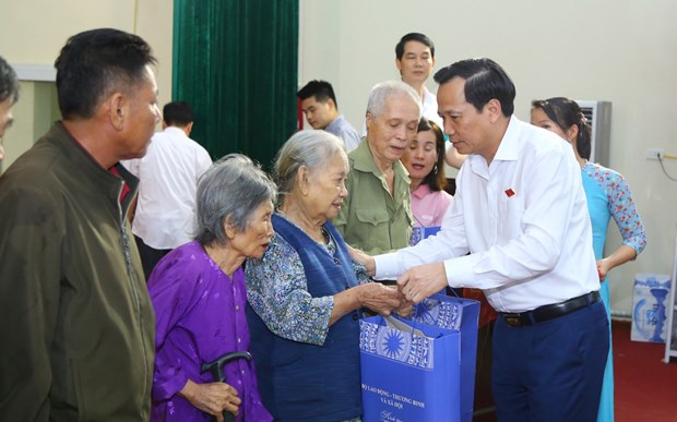 Bộ trưởng Đào Ngọc Dung trao tặng quà cho các gia đình chính sách, người có công. (Ảnh: PV/Vietnam+)