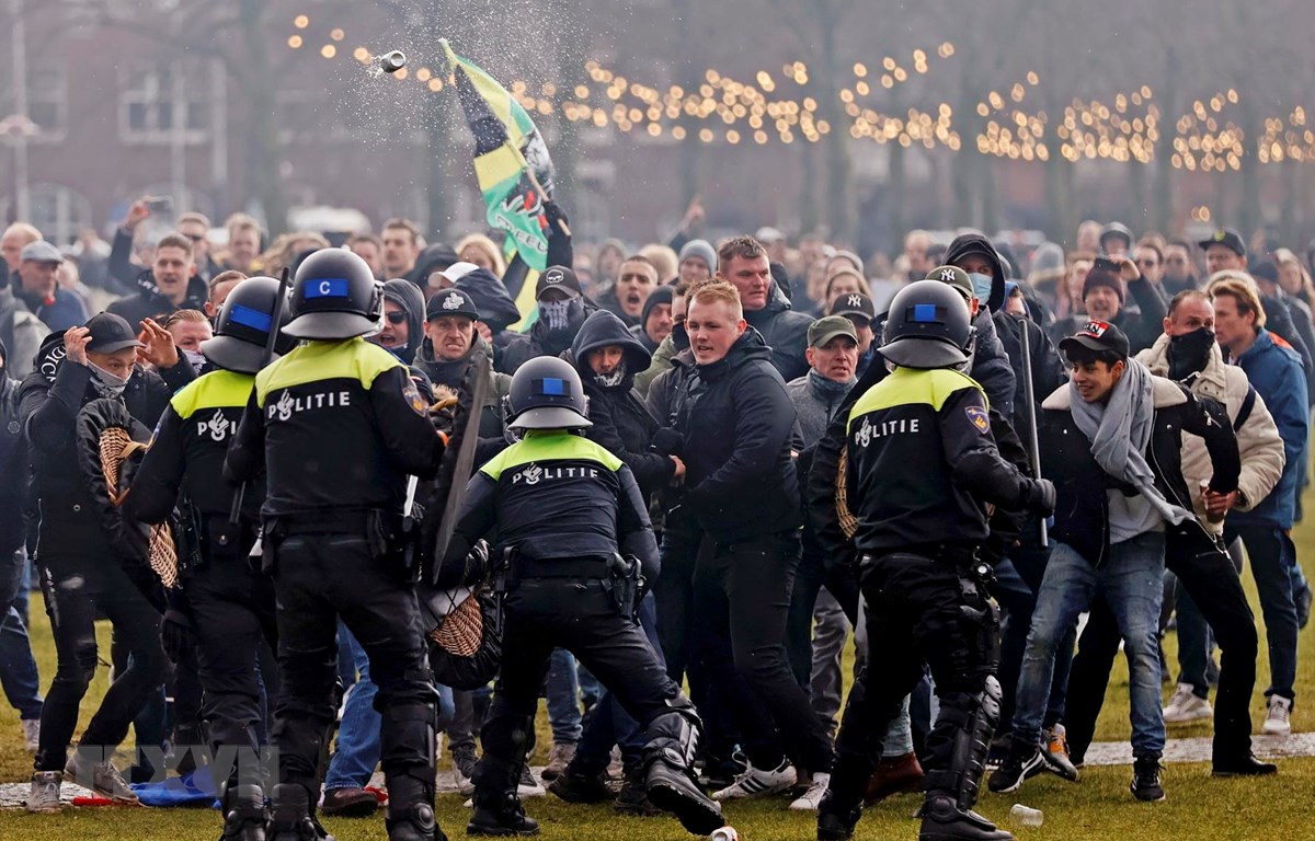  Cảnh sát chống bạo động giải tán người biểu tình tại Amsterdam, Hà Lan ngày 17-1. (Ảnh: AFP/TTXVN)