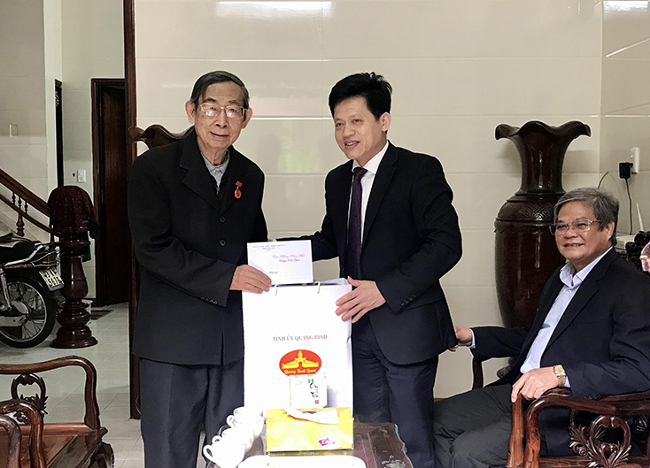 Đồng chí Trưởng ban Dân vận Tỉnh ủy Lê Văn Bảo tặng quà Tết cho đồng chí Lê Công Minh.