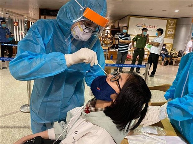  Nhân viên y tế lấy mẫu xét nghiệm cho người làm việc tại sân bay Tân Sơn Nhất ngày 6-2. (Ảnh: TTXVN phát)