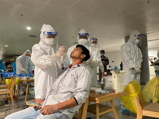 Nhân viên y tế lấy mẫu xét nghiệm cho người làm việc tại sân bay Tân Sơn Nhất ngày 6-2. (Ảnh: TTXVN phát)
