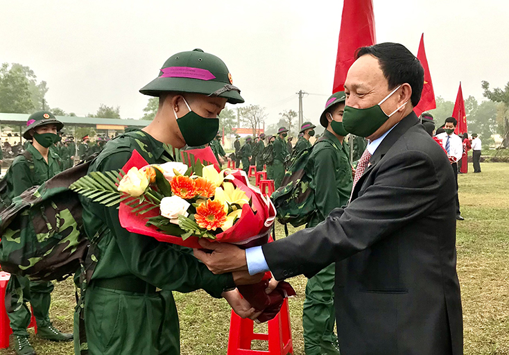 Đồng chí Phó Bí thư Thường trực Tỉnh uỷ Trần Hải Châu tặng hoa chúc mừng tân binh lên đường nhập ngũ.