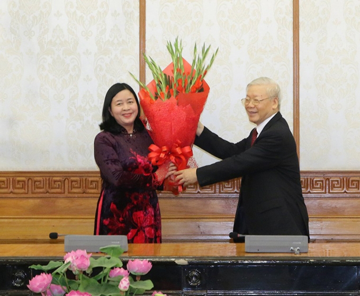  Tổng Bí thư Nguyễn Phú Trọng trao quyết định và tặng hoa chúc mừng đồng chí Bùi Thị Minh Hoài, Trưởng Ban Dân vận Trung ương. 