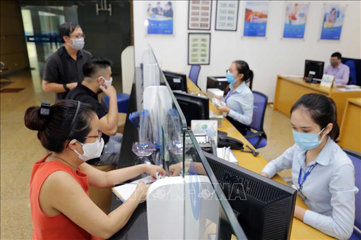   Khách hàng giao dịch tại ngân hàng. Ảnh minh họa: Trần Việt/TTXVN