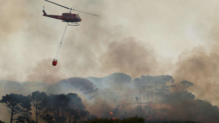 Ngọn lửa bùng phát trên các sườn núi gần Đài tưởng niệm Rhodes Memorial. Ảnh: Reuters