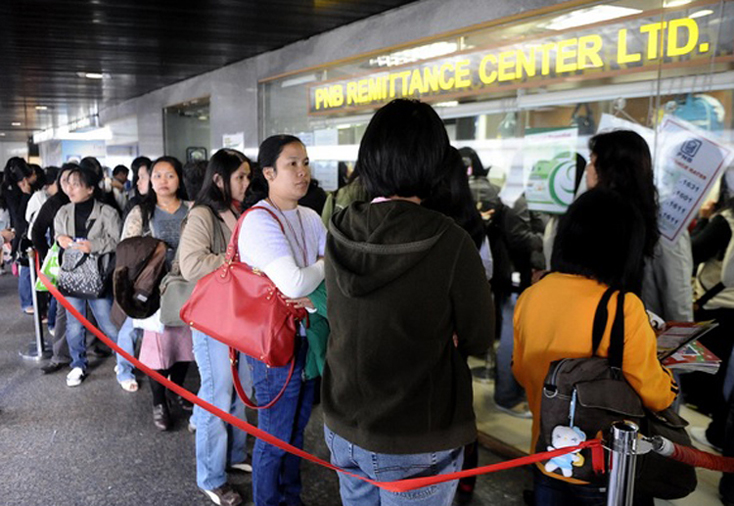 Người lao động Philippines tại Hong Kong (Trung Quốc) xếp hàng để gửi tiền về quê nhà. Ảnh: AFP