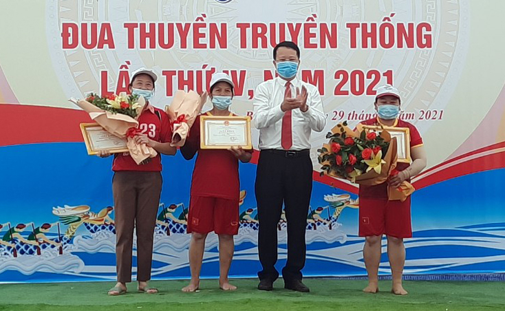 Phó Chủ tịch UBND huyện Nguyễn Hữu Hồng trao giải nhất nhì ba cho các thuyền đua nữ