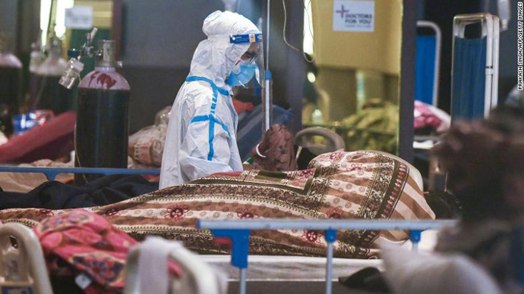 Một nhân viên y tế mặc đồ bảo hộ  kiểm tra bệnh nhân tại một bệnh viện dã chiến ở New Delhi ngày 1-5. Ảnh: CNN