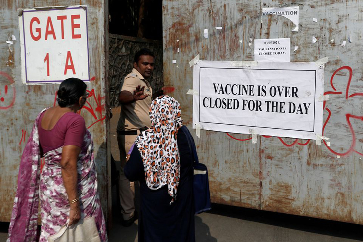 Cảnh sát yêu cầu người dân ra về trước cửa một trung tâm tiêm chủng vì đã hết vaccine. Ảnh: Reuters