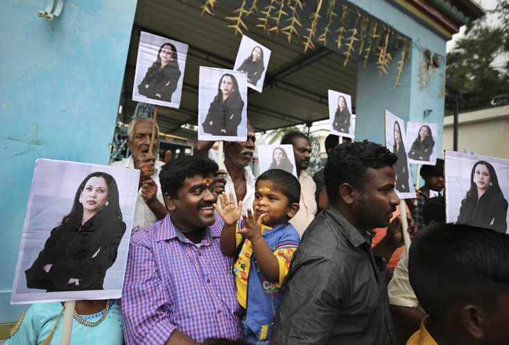 Dân làng cầm ảnh của Phó Tổng thống Kamala Harris sau khi tham gia lễ cầu nguyện đặc biệt trước lễ nhậm chức của bà, bên ngoài một ngôi đền Hindu ở Thulasendrapuram, phía nam Chennai, bang Tamil Nadu, Ấn Độ hôm 20-1.  Ảnh AP