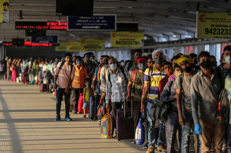 Hành khách xếp hàng trong năng nóng tại một chốt kiểm soát gần nhà ga Pune  ở bang Maharashtra. Ảnh: Bloomberg