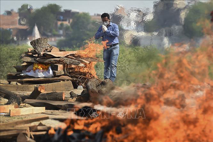 Cầu nguyện trong lễ hỏa táng người thân tử vong do nhiễm COVID-19 tại Allahabad, Ấn Độ, ngày 8-5-2021. Ảnh: AFP/TTXVN