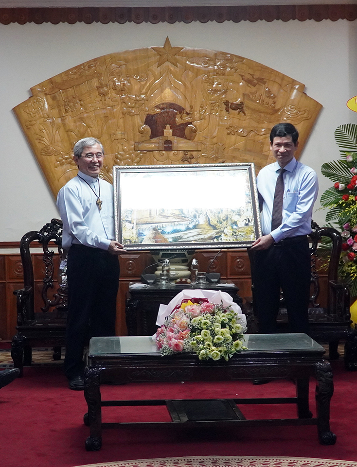 Đồng chí Phó Chủ tịch UBND tỉnh Hồ An Phong tặng quà cho Giám mục Nguyễn Anh Tuấn.